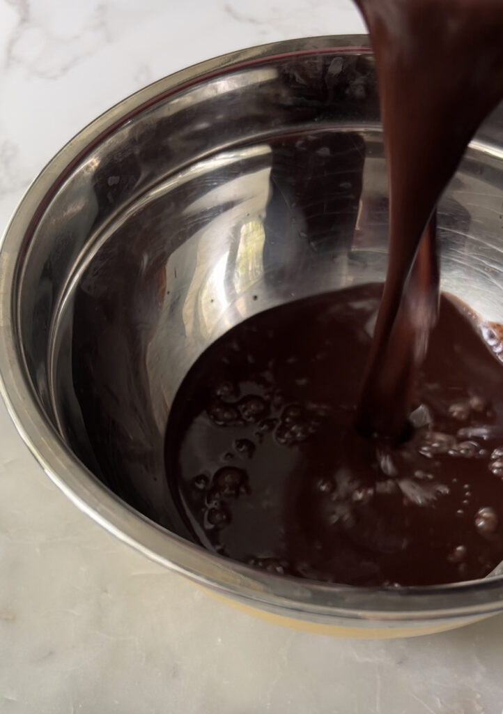 chocolate pouring into a metal pan 