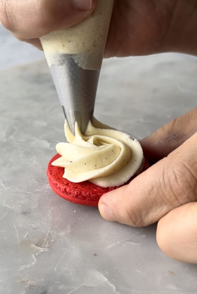 piping whipped ganache on a macaron 